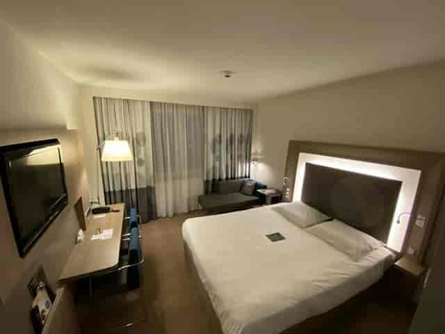 Modern corporate guest room with desk for business travel and conference lodging.