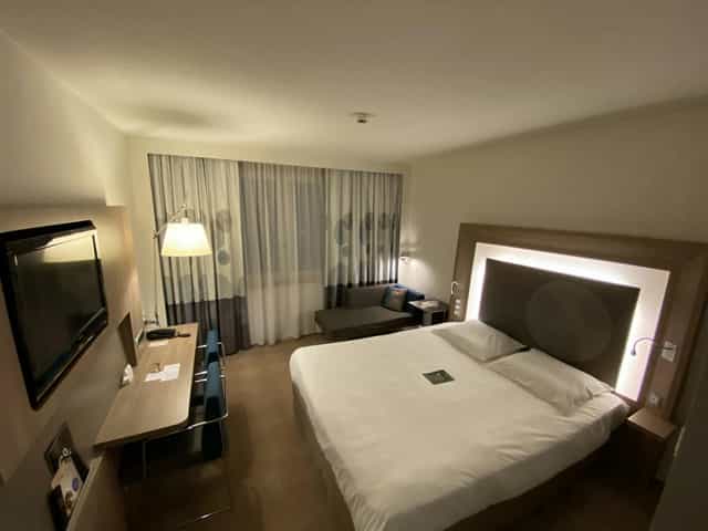 Modern corporate guest room with desk for business travel and conference lodging.