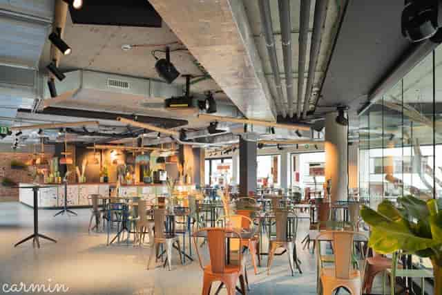 Industrial-chic meeting room with exposed ceilings, ideal for networking and corporate events.