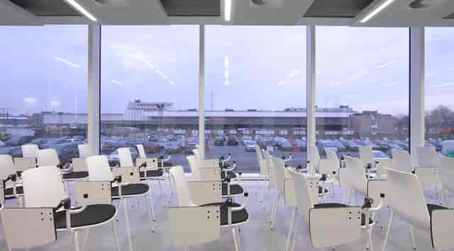 Modern BEL auditorium training room with tablet-arm chairs for corporate events and workshops.