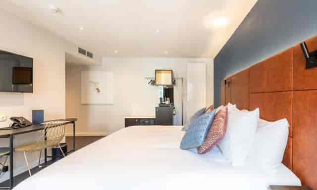 Modern Hotel Sablon suite with workspace for business travel and conference stays.