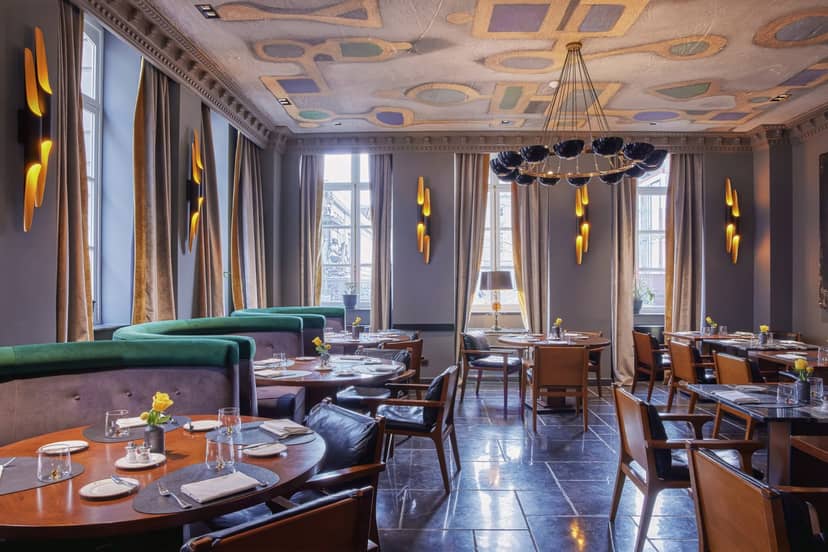 Luxury restaurant banquet space with green banquettes for upscale networking and boutique events.