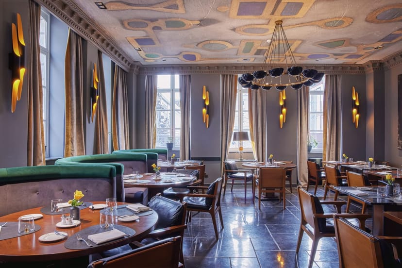 Luxury restaurant banquet space with green banquettes for upscale networking and boutique events.
