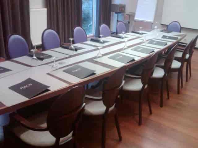 Boardroom at The Augustin Brussels with mauve chairs for corporate meetings and event venues.