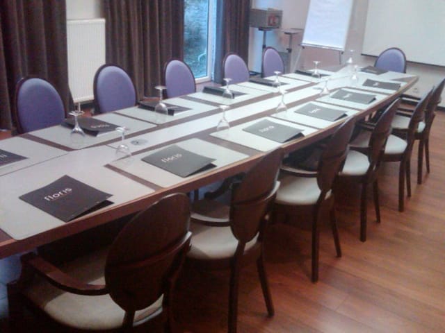 Boardroom at The Augustin Brussels with mauve chairs for corporate meetings and event venues.