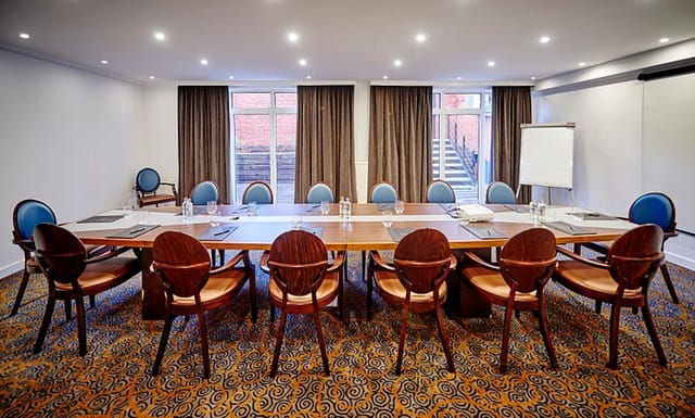 Boardroom at The Augustin Brussels with natural light for strategic planning and executive meetings.