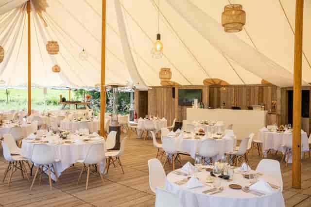 Rustic marquee event hall in Kattebroek with modern seating and ambient lighting.