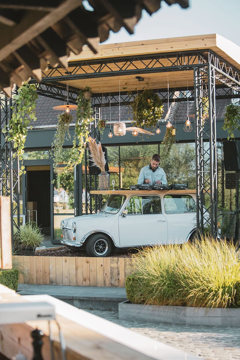 Vintage Mini Cooper DJ booth at Winter garden event, botanical experiential marketing installation.