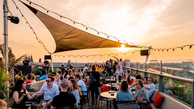 Rooftop networking reception at The 1040 with string lights and lounge seating for corporate events.
