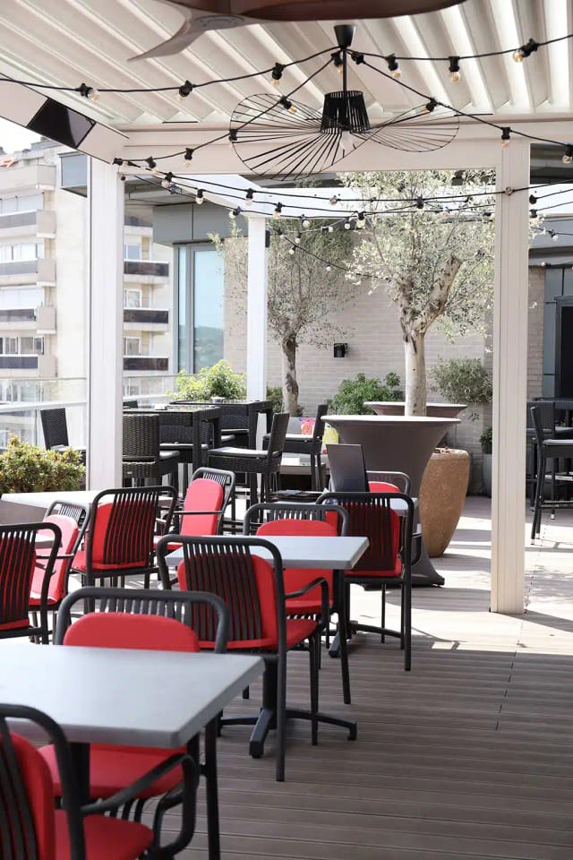Rooftop bar with cocktail tables for corporate networking and al fresco business mixers.