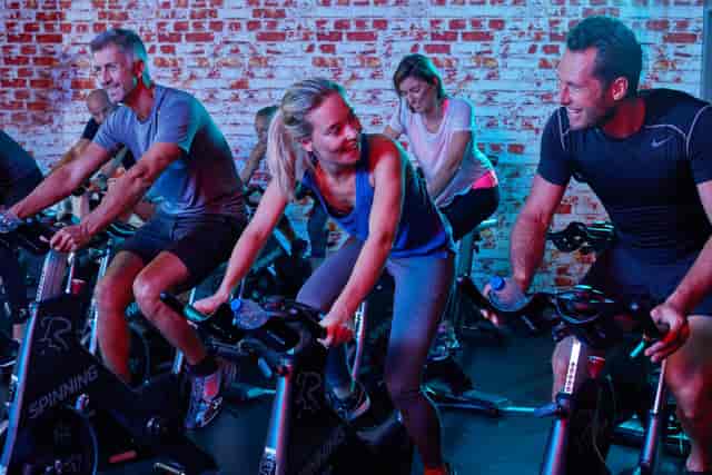 Cycling studio at Aspria Royal La Rasante with immersive lighting for corporate event fitness.