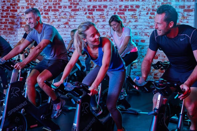 Cycling studio at Aspria Royal La Rasante with immersive lighting for corporate event fitness.