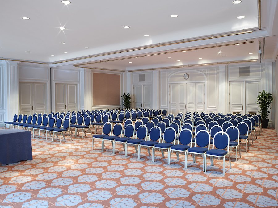 Banquet hall conference room with blue chairs in Hilton Brussels for events and workshops.