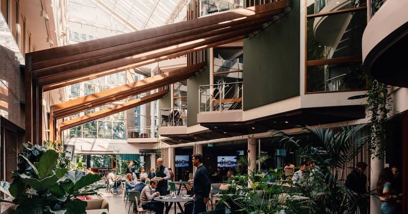Think Big networking reception in light-filled Epicenter Oslo atrium with biophilic design.