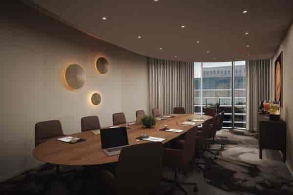 Executive boardroom for SIXA Conference strategy meeting with natural light and refreshment area.