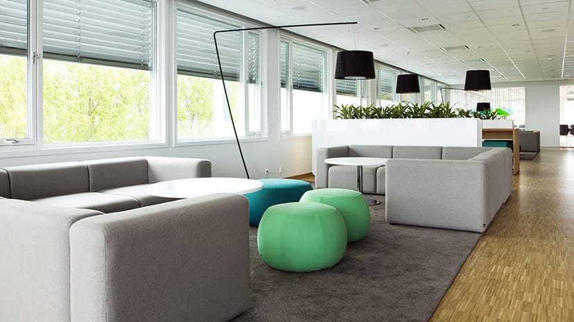 Modular lounge seating in a modern corporate breakout space for networking and conference events.