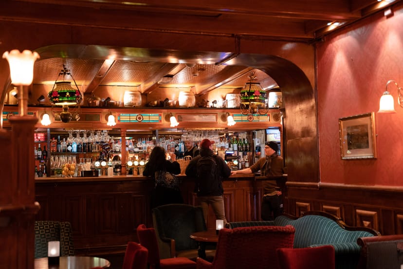 Upscale wood-paneled bar for intimate post-conference networking and VIP reception events.
