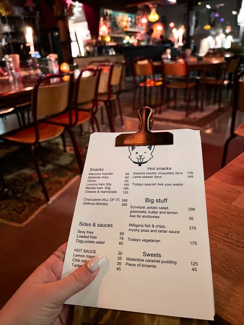 Casual bar menu on clipboard for informal corporate event or post-conference happy hour.