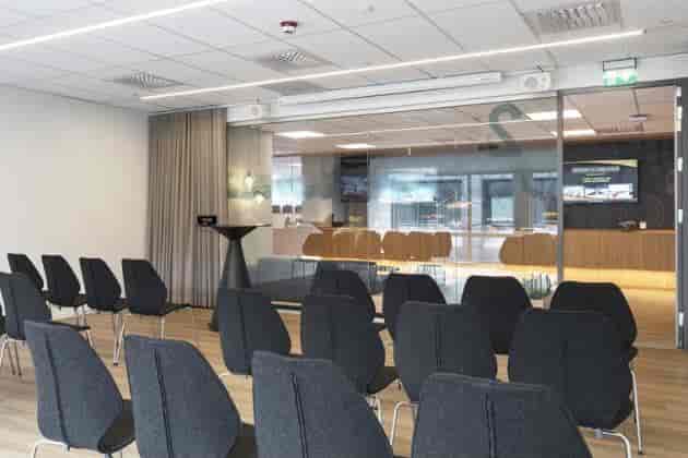 Modern theater-style breakout space with glass partitions for corporate events and workshops.