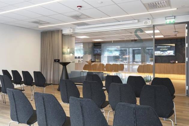 Modern theater-style breakout space with glass partitions for corporate events and workshops.