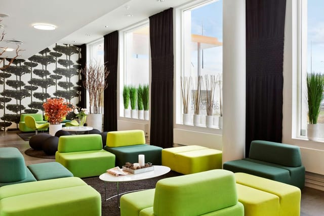 Modern breakout room with green modular seating for corporate conferences and networking events.