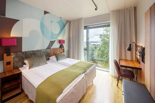 Modern twin guest room at Scandic Solli with workstation, ideal for corporate travel and conferences.