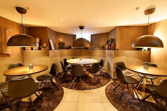 Lobby bar at Saga Hotel Oslo featuring modular round tables for business meetings and networking.