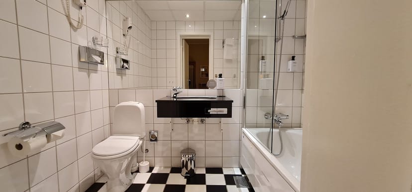 Scandic Holberg hotel bathroom: functional, dated suite for budget corporate event bookings.