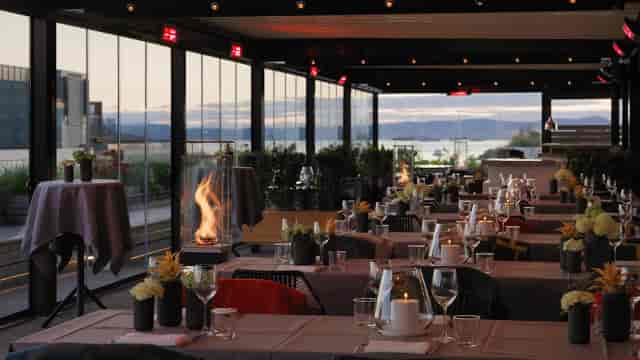 Thief Roof Bar: Glass-walled rooftop event venue with elegant lighting for evening receptions.