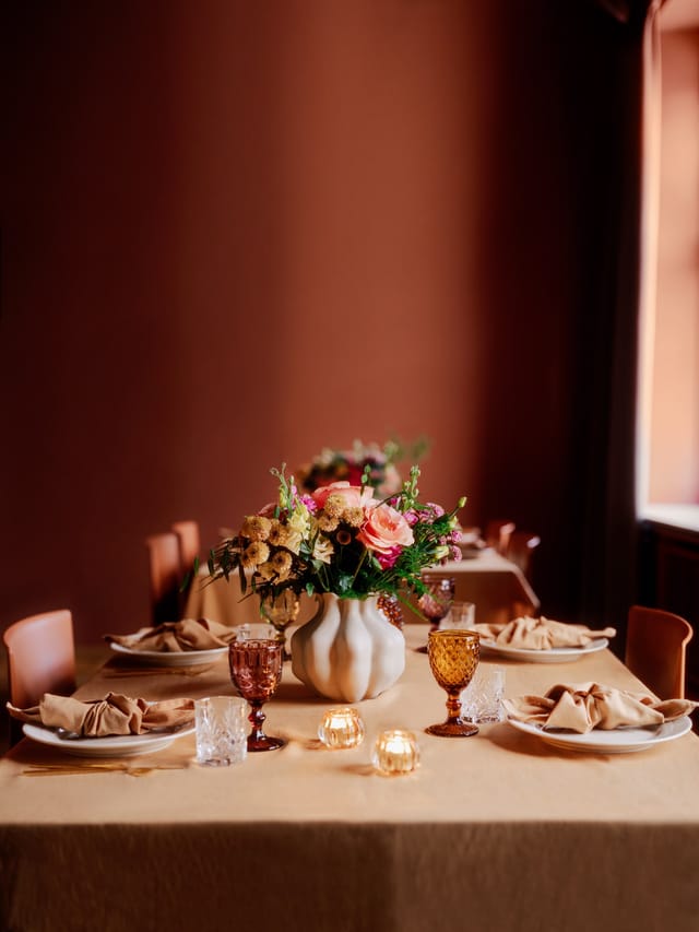 Executive dinner setup at Møterom Kjøpmannen, Handelens Hus with elegant floral banquet decor.