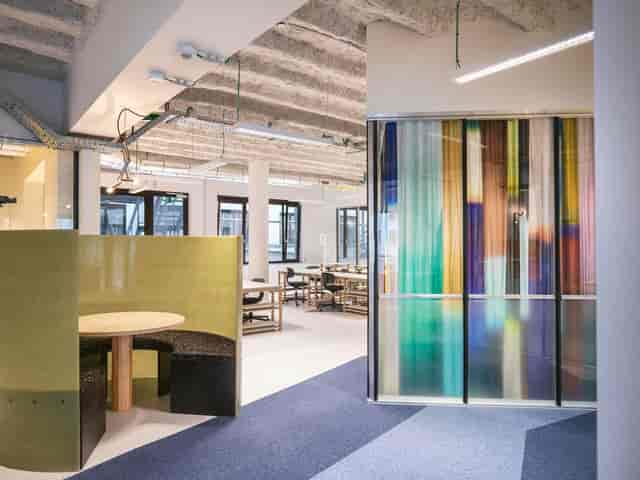 Modern coworking breakout space with acoustic seating for business meetings and hybrid work events.