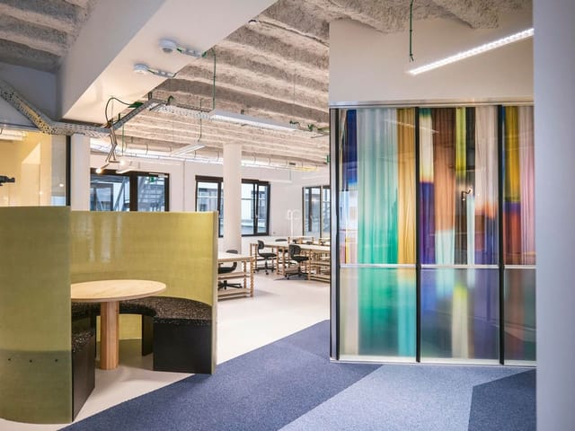 Modern coworking breakout space with acoustic seating for business meetings and hybrid work events.
