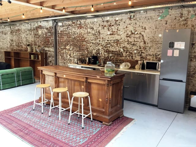 Industrial-chic Palazzo coworking space with rustic bar for corporate networking events.