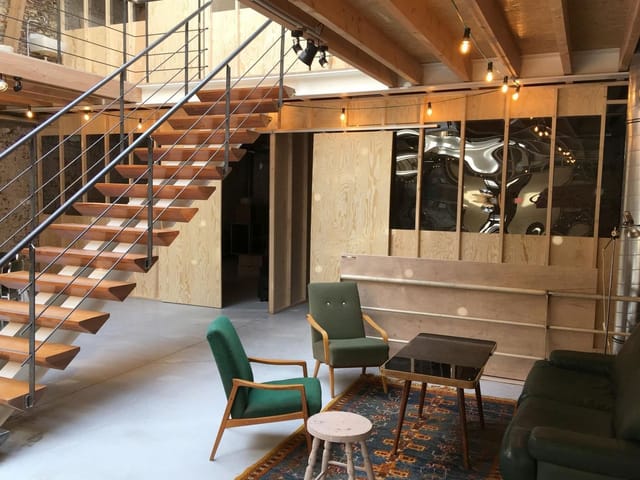 Industrial-chic coworking space in Palazzo with modern staircase for creative networking events.