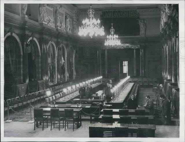 Formal long-table banquet setup in Palais des Académies conference center for corporate events.
