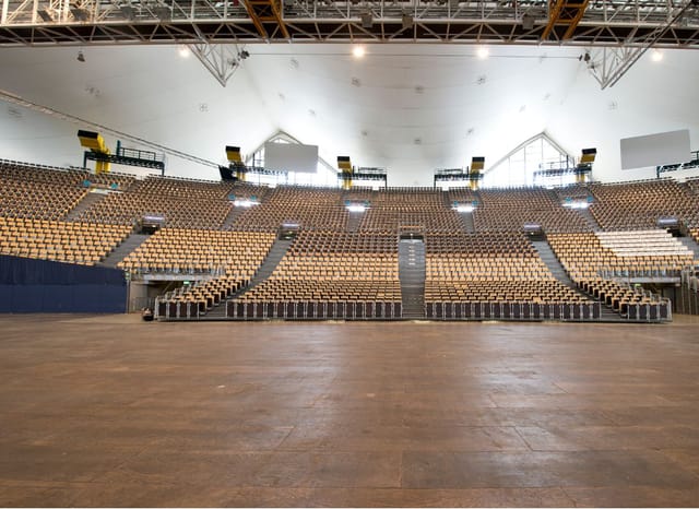 Olympiahalle arena with tiered seating for trade shows and plenary sessions.