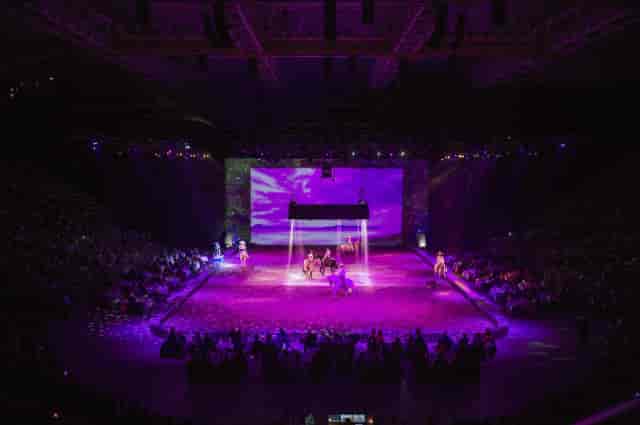 Equestrian performance in Olympiahalle with purple stage lighting, live event, arena show.