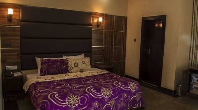 Oranmiyan Hall, Lagos Airport Hotel room with patterned bedding for corporate event bookings.