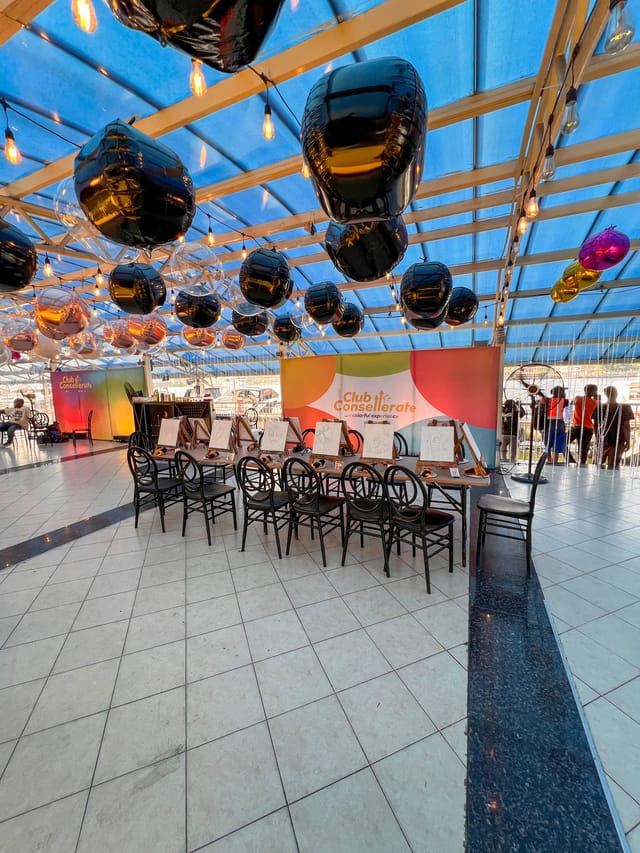 Outdoor creative workshop venue with balloon decor for branded paint-and-sip events.