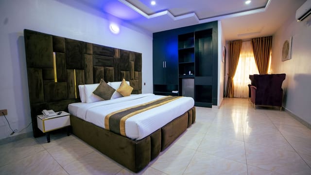 Modern hotel guest room with upholstered headboard for corporate lodging and business travel.