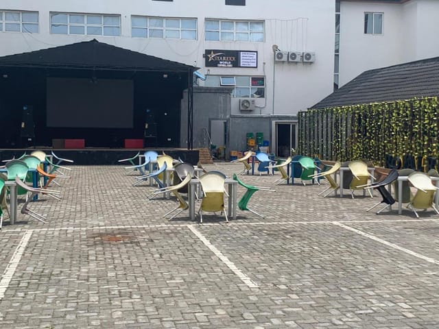 Outdoor lounge event space at Royalrex Hotels with stage and paved seating for corporate events.