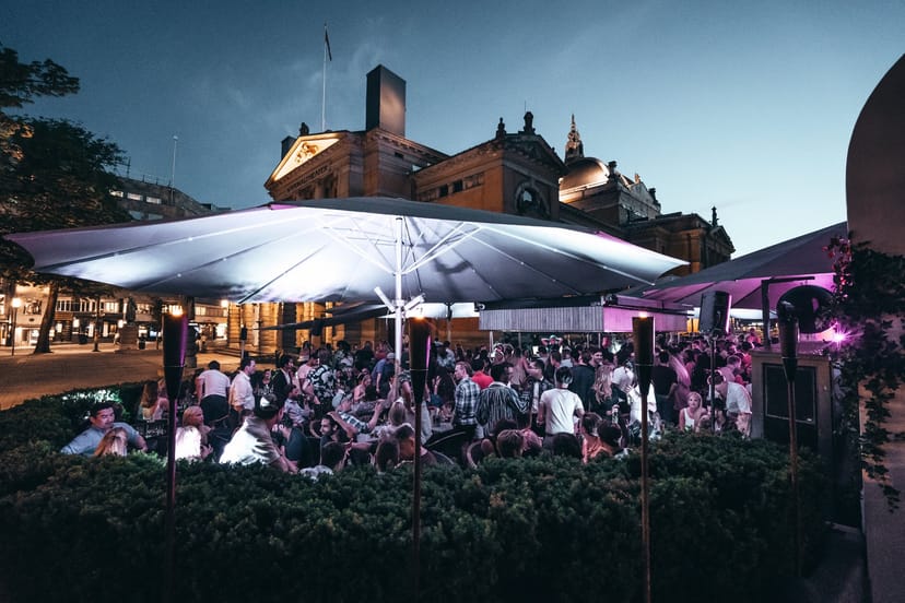 Outdoor networking reception at Lawo Terrasse with ambient lighting and umbrellas.