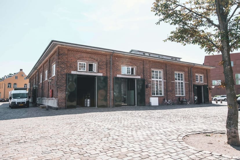 Industrial-chic Pakhus 11 Smedjen venue with raw brick for event hosting and networking.