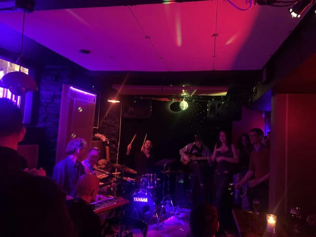 Live band performing at 4Tallet corporate breakout session with accent lighting.