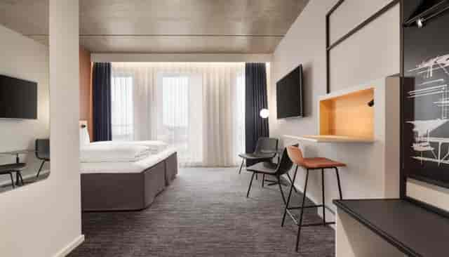 Modern hotel room with workspace at Comwell Copenhagen Portside, ideal for business and conferences.