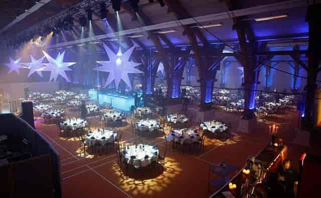 Julefrokost gala in industrial venue with star decor and atmospheric lighting for event planning.