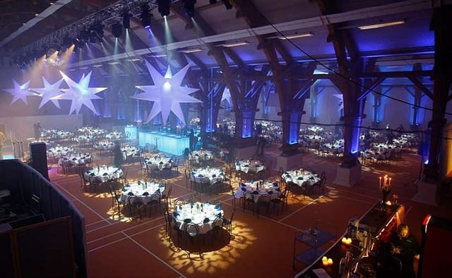 Julefrokost gala in industrial venue with star decor and atmospheric lighting for event planning.
