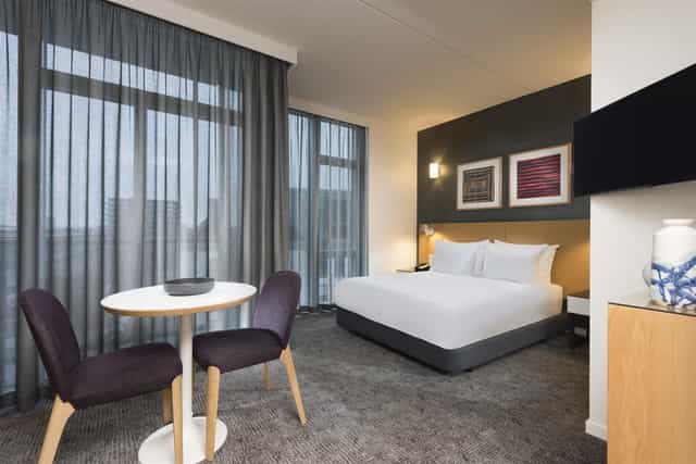 Modern hotel room with dedicated workspace, ideal for business travel and corporate meetings.