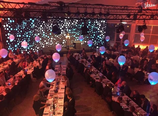 Gala banquet hall in Marketenderiet with immersive LED backdrop and hanging decor for event planning.