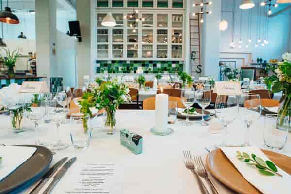 Rustic-chic banquet hall with botanical decor for wedding reception or intimate dinner event.